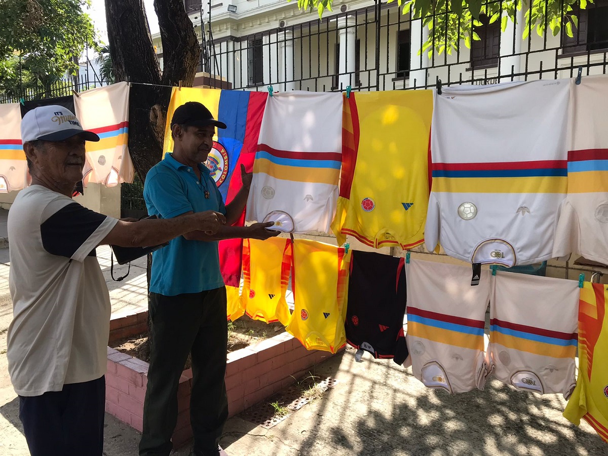 El comerciante Julio Pinedo Mendoza, ofrece las camisetas de la selección Colombia previo al partido